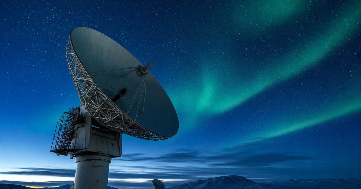 オーロラの空の下で衛星通信を受信する地上局アンテナ